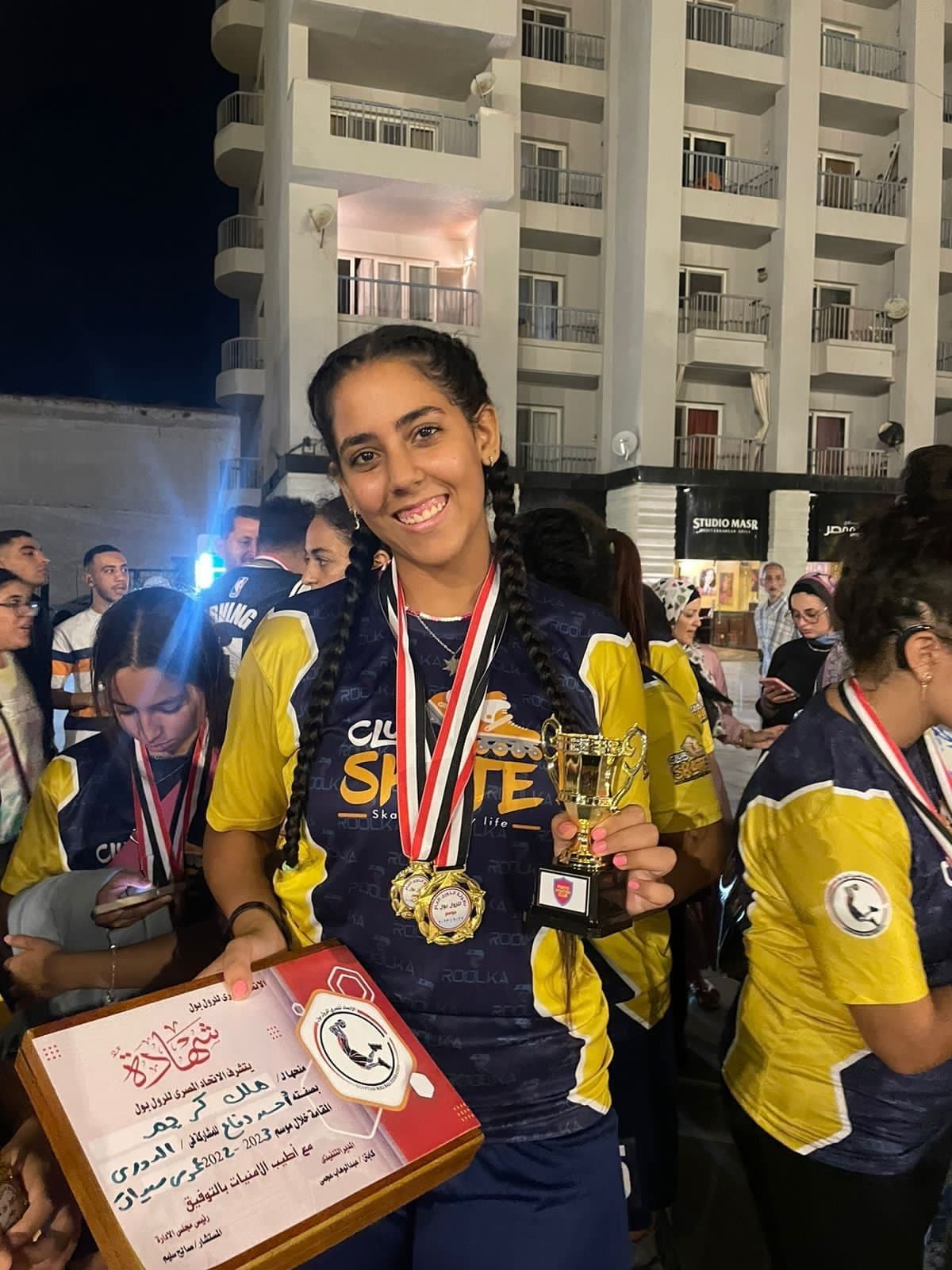 لاعبة مع ميدالياتها وكأسها